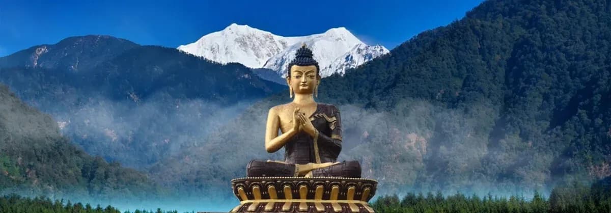 Large golden Buddha statue at Tathagata Tsal, Ravangla, with mountain scenery.